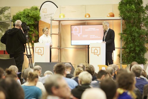 Moderatorin Janine Steeger und Frank Hettler, Leiter von Zukunft Altbau, auf der Bühne im Gespräch.