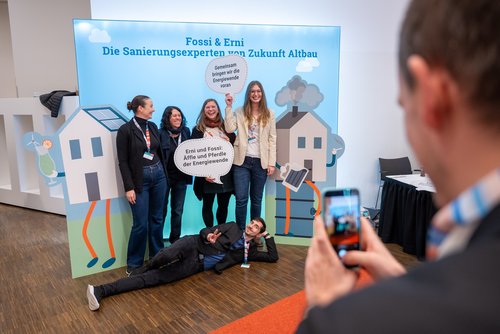 Das Foto zeigt mehrere Personen beim Posieren vor der Fotowand auf dem Herbstforum Altbau 2025.