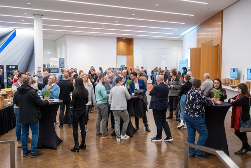 Das Foto zeigt die Teilnehmenden beim Herbstforum Altbau 2025 beim Netzwerken im Foyer.