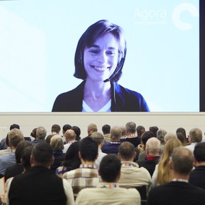 Referentin Uta Weiß ist online zugeschaltet und auf der großen Leinwand hinter der Bühne zu sehen. 