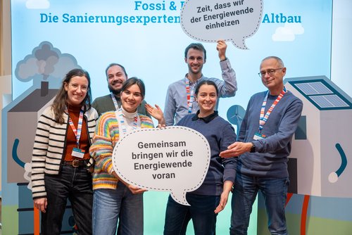 Das Foto zeigt mehrere Personen beim Posieren vor der Fotowand auf dem Herbstforum Altbau 2025.