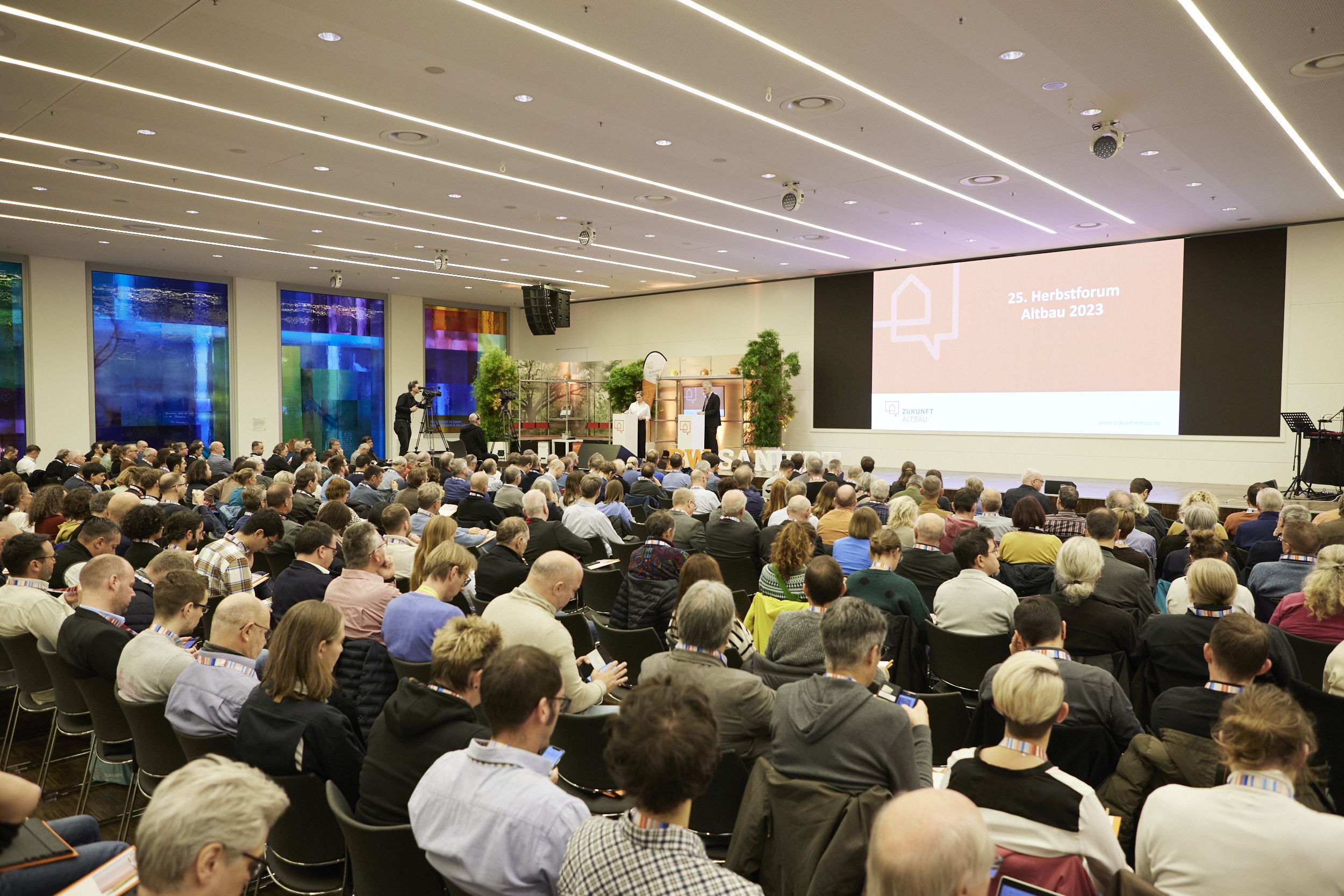 Bild zeigt die Veranstaltung Herbstforum Altbau. Zu sehen ist die große Bühne und ein Teil des großen Publikums.