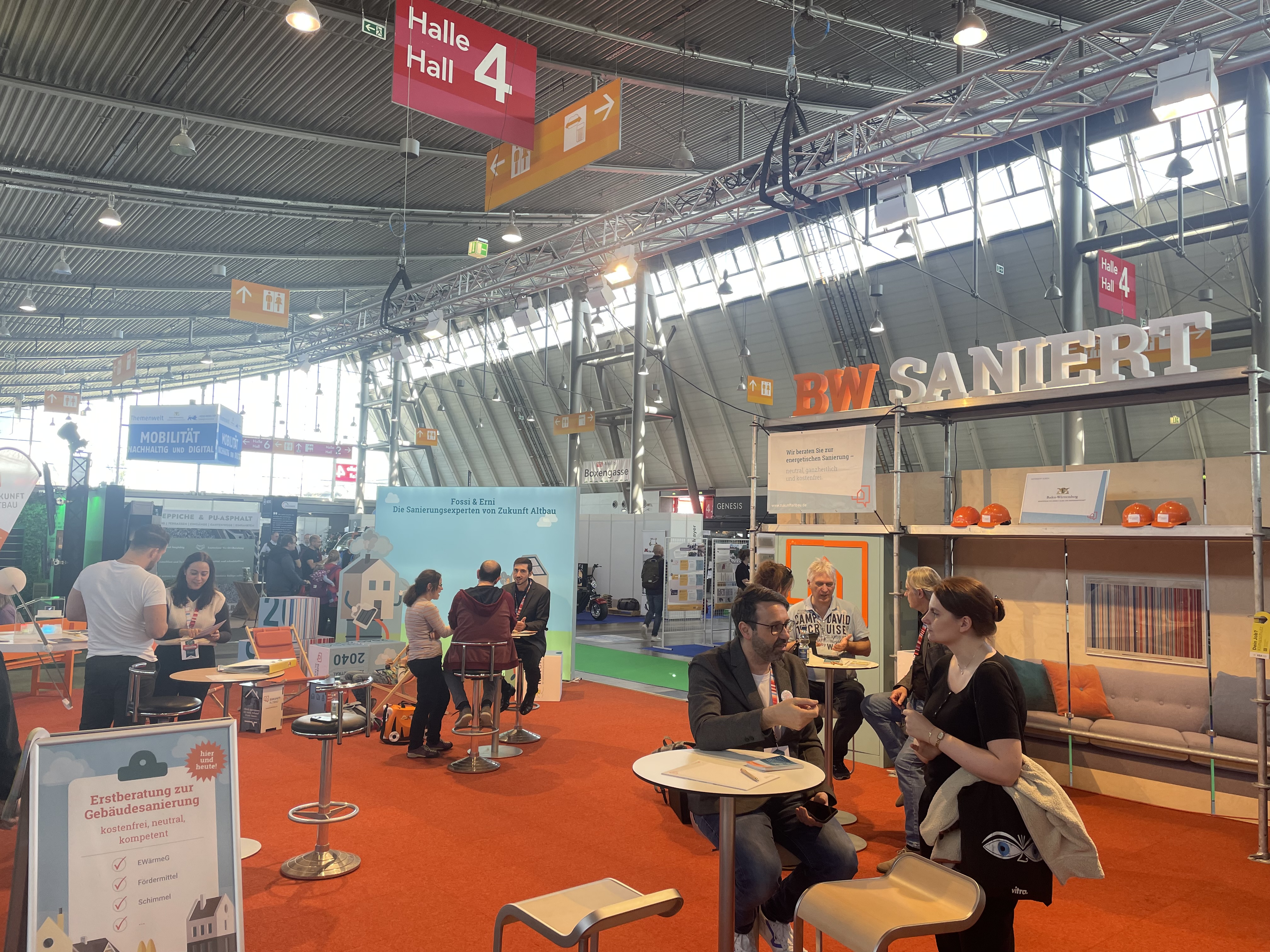 Veranstaltungshalle mit verschiedenen Informationsständen.